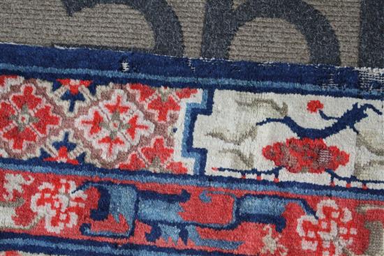 A small Chinese Suiyvan carpet, the fawn ground field woven with a lattice pattern, each cross centred by flowerheads, within a border